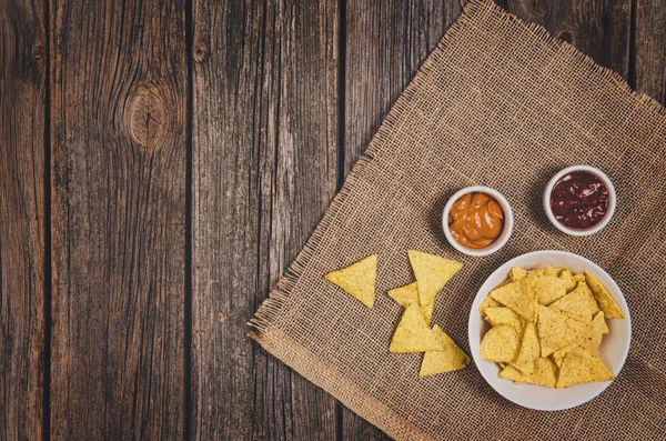 Hoop van chips in kom op houten tafel achtergrond — Stockfoto