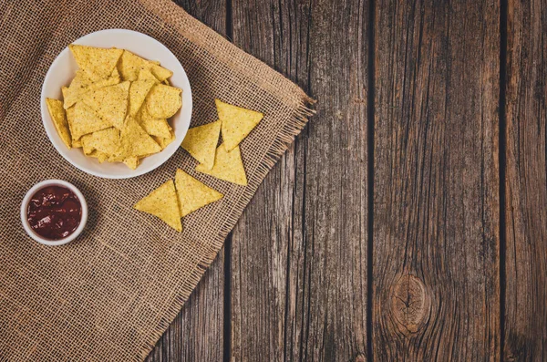 Hoop van chips in kom op houten tafel achtergrond — Stockfoto