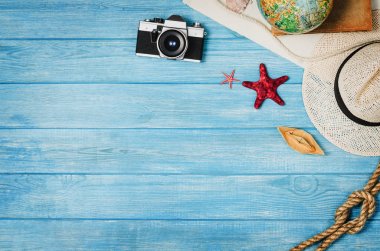 Mavi ahşap arka plan üzerinde seyahat üst görünümü için aksesuarlar