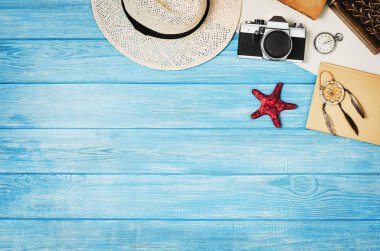 Mavi ahşap arka plan üzerinde seyahat üst görünümü için aksesuarlar