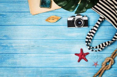 Mavi ahşap arka plan üzerinde seyahat üst görünümü için aksesuarlar