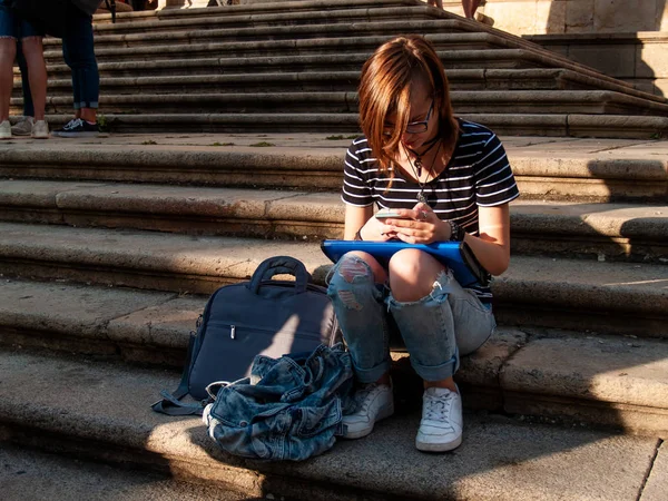 Ellerini historial bir bina merdivenlerde bir akıllı telefon olan genç bir kadın