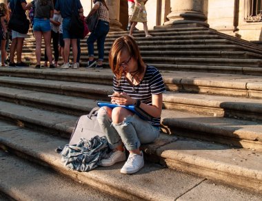 Ellerini historial bir bina merdivenlerde bir akıllı telefon olan genç bir kadın