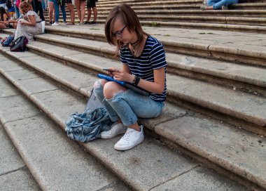 Ellerini historial bir bina merdivenlerde bir akıllı telefon olan genç bir kadın