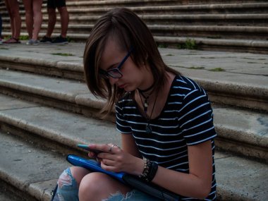 Ellerini historial bir bina merdivenlerde bir akıllı telefon olan genç bir kadın