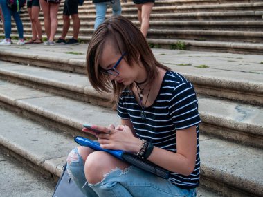 Ellerini historial bir bina merdivenlerde bir akıllı telefon olan genç bir kadın