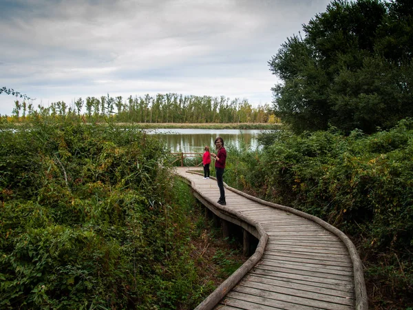 两个年轻的妇女在一个观点与木栏杆考虑在秋天的河流 — 图库照片