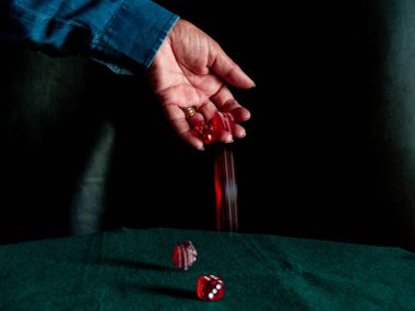 Yeşil bir halı üzerinde zar atma bir kişinin el