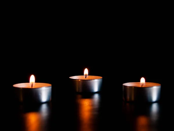 Tre Candele Accese Con Una Fiamma Arancione Isolate Fondo Nero — Foto Stock