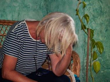 Hüzün ve bunalım gösterilen üzgün bir kadın başını elinde, dinlenme