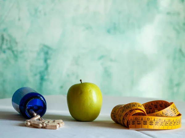 Una Manzana Una Cinta Métrica Recipiente Azul Con Píldoras Fibra — Foto de Stock