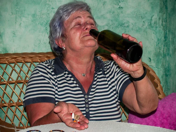 Uma Mulher Sênior Com Uma Garrafa Vinho Grande Número Pílulas — Fotografia de Stock