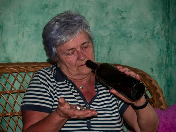 Uma Mulher Sênior Com Uma Garrafa Vinho Grande Número Pílulas — Fotografia de Stock