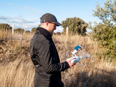 Bir dron pilot pilot ile smartphone ormanın içinde onun elinde uzaktan kumanda ile