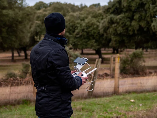Bir dron pilot pilot ile smartphone ormanın içinde onun elinde uzaktan kumanda ile