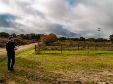 Bir dron pilot pilot ile smartphone ormanın içinde onun elinde uzaktan kumanda ile