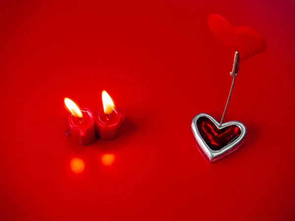Concept of love Red candles lit and red heart with a red background