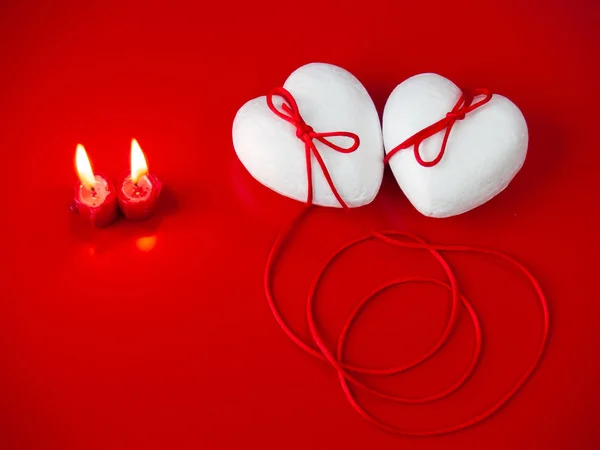 两颗小儿麻痹症的心与一根红色的线结合在一起 象征着红线和两支红色点燃的蜡烛的传说 — 图库照片