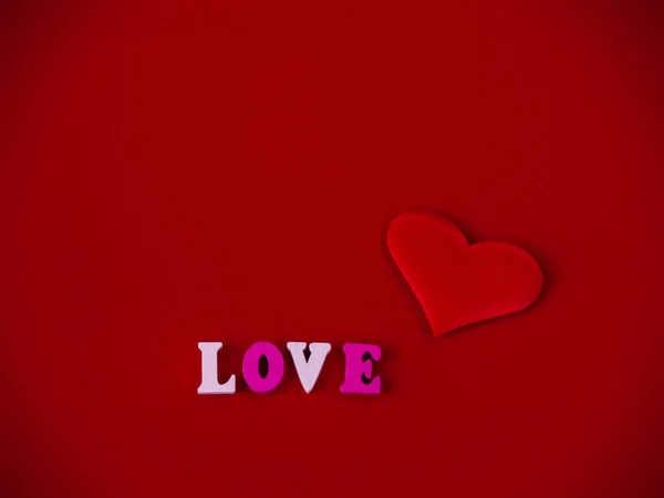 愛言葉は木製文字と背景が赤の心で愛の概念 — ストック写真