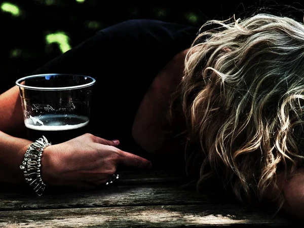 Uma Mulher Bêbada Com Copo Cerveja Mão Inconsciente Apoiada Numa — Fotografia de Stock