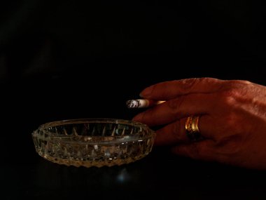 El bir kadının sigara sigara ve bir kül tablası