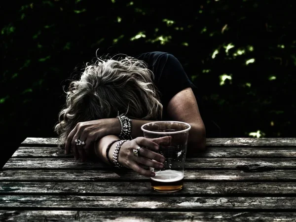 Uma Mulher Bêbada Com Copo Cerveja Mão Inconsciente Apoiada Numa — Fotografia de Stock