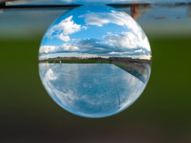 Bir kristal topu bulutlu bir günde kırsal bir manzara Yansımaları