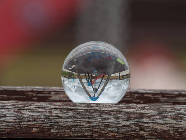 Reflections of one street in a park in a crystal ball