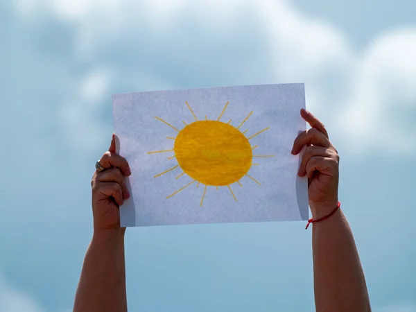 woman holding picture with sun drawn