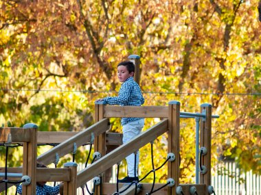  Küçük çocuk oyun bahçesinde oynuyor.