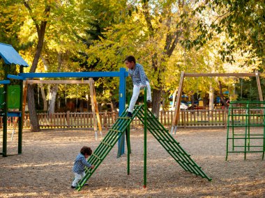 oyun alanında oynayan iki sevimli erkek