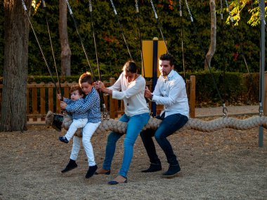 sonbaharda bir parkta salıncak sevimli küçük erkek ve anne