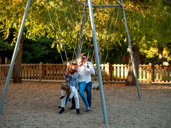 Schattige Kleine Jongens Ouders Swing Een Park Herfst — Stockfoto