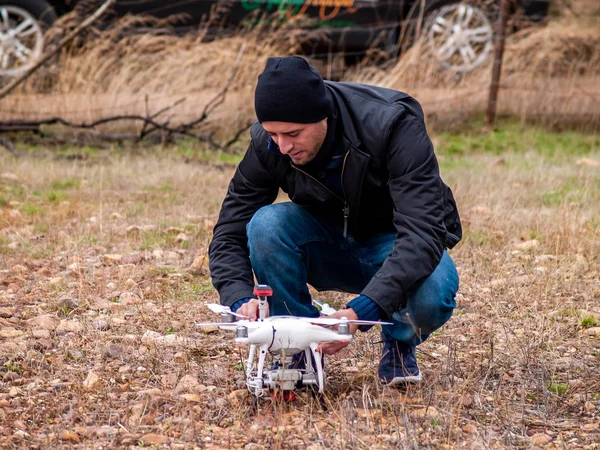 A drone pilot configuring his drone in the forest before flying