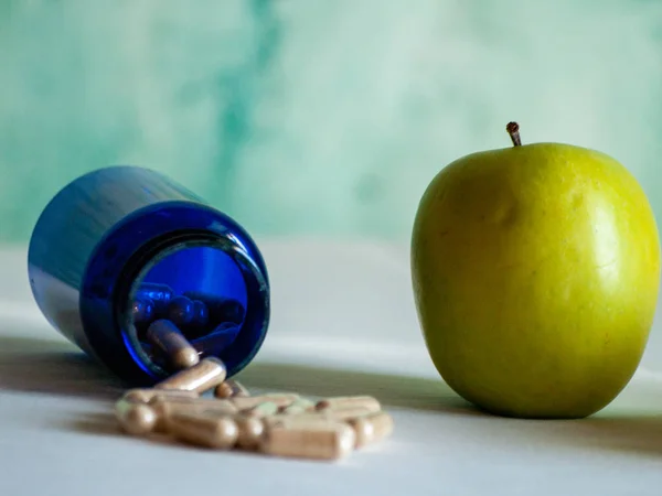 Una Mela Contenitore Blu Con Pillole Fibra Vegetale Tavolo — Foto Stock