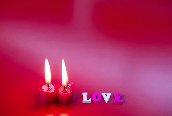 愛赤いキャンドル点灯と背景が赤の単語の愛の概念 — ストック写真