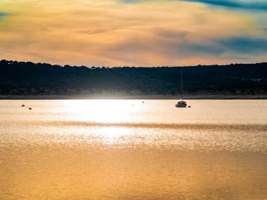 Gün batımında, gölde tekne şamandıra ve La Maya rezervuarı sakin suda demirli