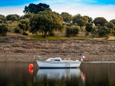 Gün batımında, gölde tekne şamandıra ve La Maya rezervuarı sakin suda demirli