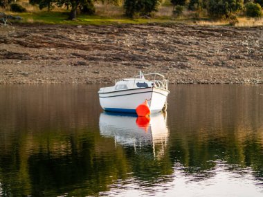Gün batımında, gölde tekne şamandıra ve La Maya rezervuarı sakin suda demirli