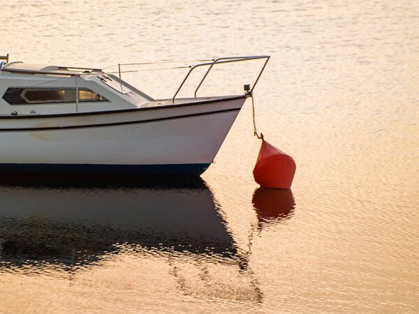 Boat on a lake at sunset, moored in the reservoir of La Maya, Spain