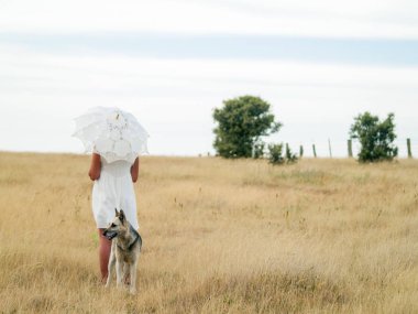 Tarlada şemsiyesi olan bir kadın.  