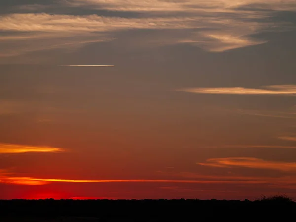 Romantischer Orangefarbener Himmel Bei Sonnenuntergang Mit Wenigen Wolken Und Chemtrails — Stockfoto