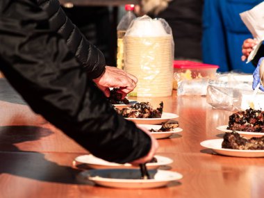 Tanınmayan kişi üzerinden İspanya bir köyde popüler bir partide sokakta bir kağıt tabak pişmiş et alarak