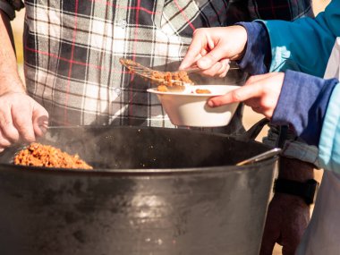 Tanınmayan kişi geleneksel İspanyol yemekleri sunan bir kağıt tabak İspanya bir köyde popüler bir partide sokakta chichas çağrıda
