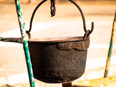 Bir şenlik ateşi sokakta asılı eski paslı demir tencere