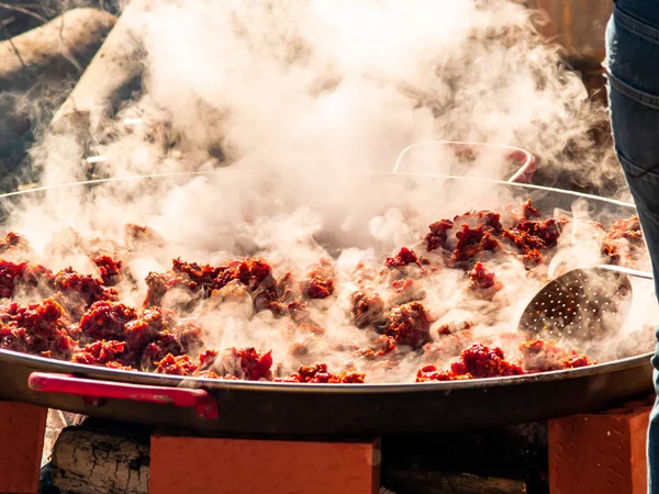 Unerkennbare Person kocht auf der Straße bei einer Volksfeier in einem Dorf in Spanien traditionelle Speisen namens chichas — Stockfoto
