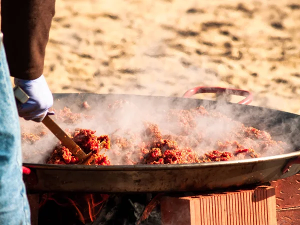 Onherkenbaar persoon koken traditionele food chichas opgeroepen de straat op een populaire feestje in een dorp in Spanje — Stockfoto