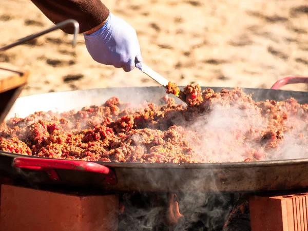 Persona irriconoscibile che cucina cibo tradizionale chiamato chichas per strada a una festa popolare in un villaggio in Spagna — Foto Stock