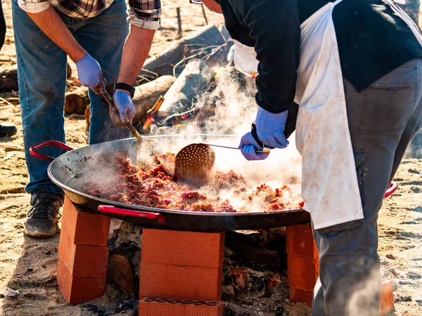 Unerkennbare Person kocht auf der Straße bei einer Volksfeier in einem Dorf in Spanien traditionelle Speisen namens chichas — Stockfoto