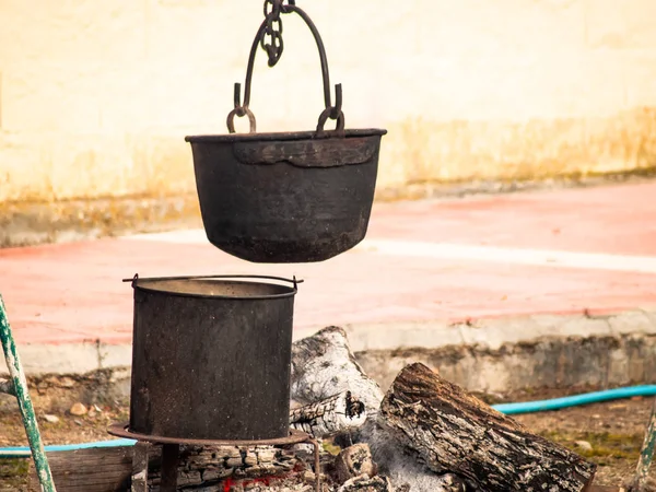 Old rusty iron pots hanging in the street on a bonfire — Stock Photo, Image